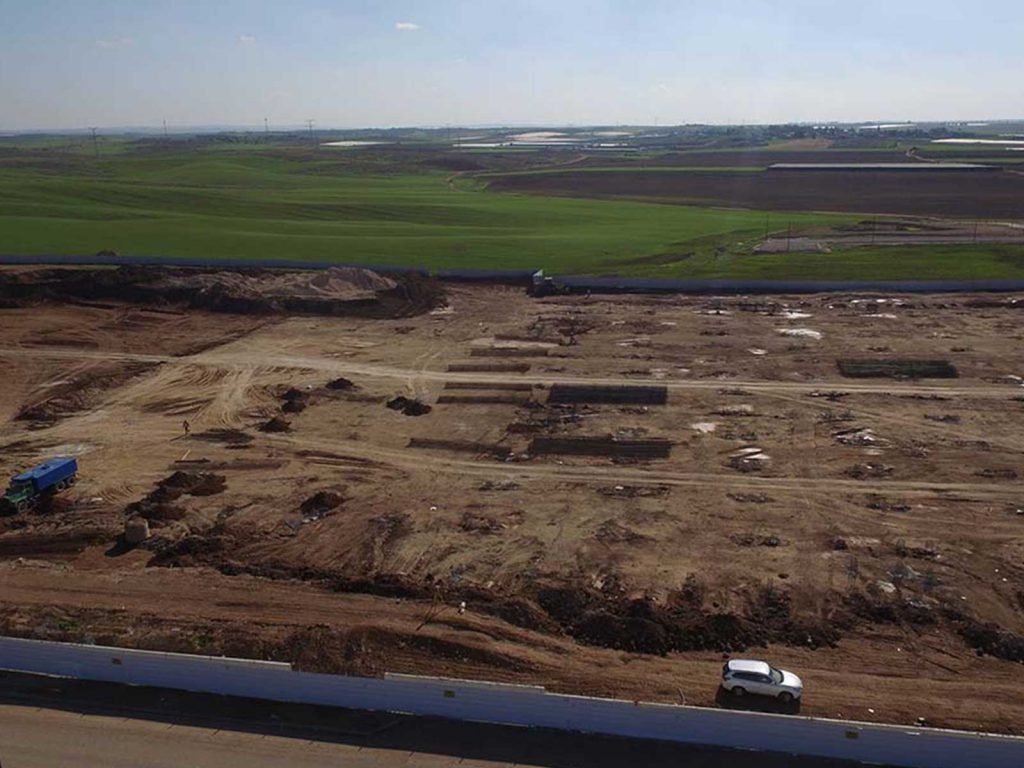 מבט אווירי של אתר בנייה באמצע שדה.