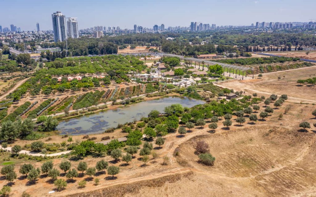 מבט אווירי של פארק אריאל שרון עם עצים ובריכה.